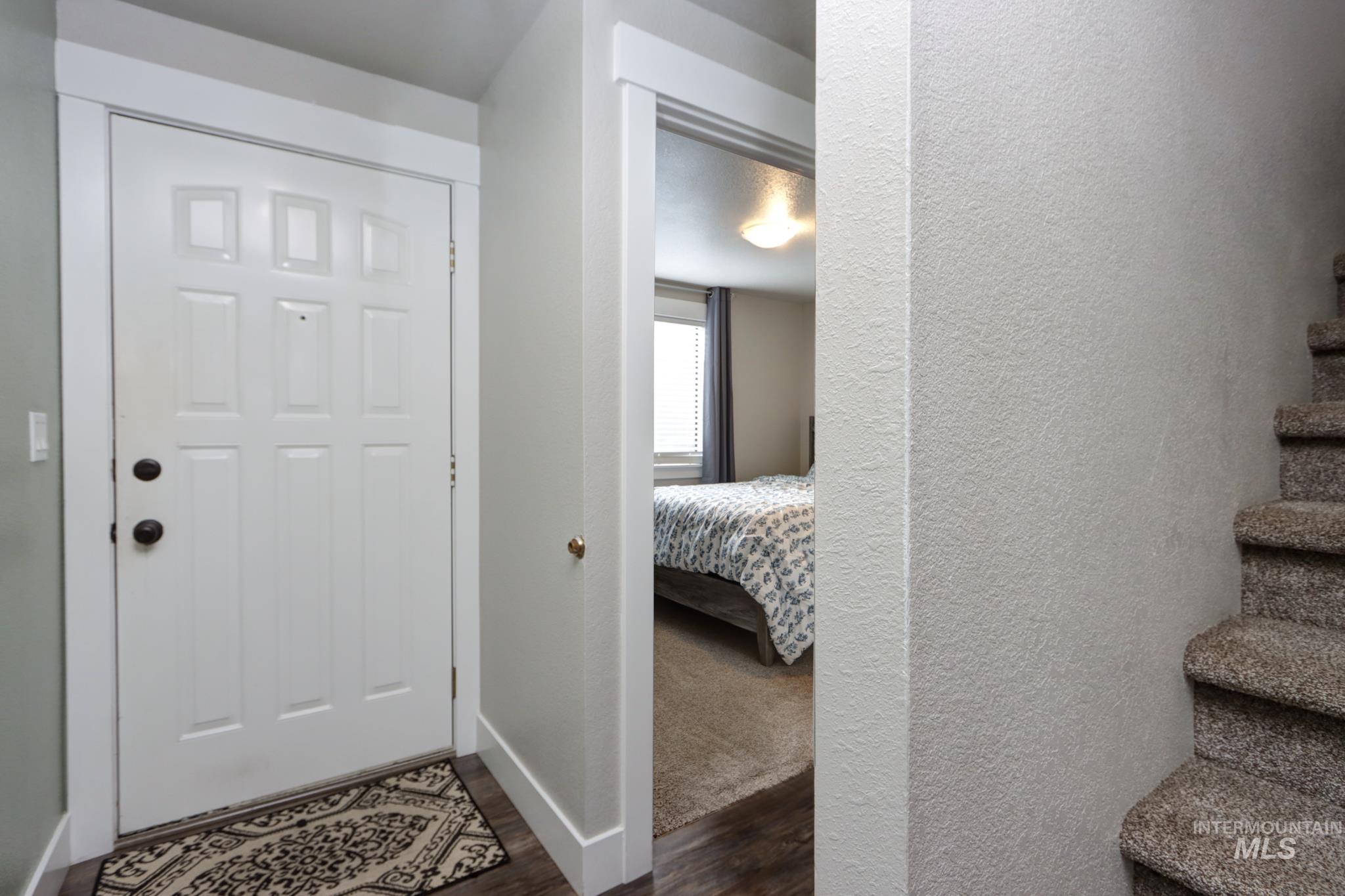 Foyer featuring dark wood finished floors and a textured wall