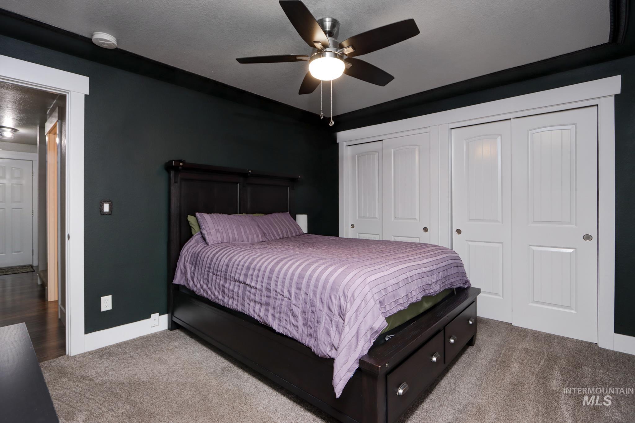 Bedroom featuring carpet, two closets, and a ceiling fan