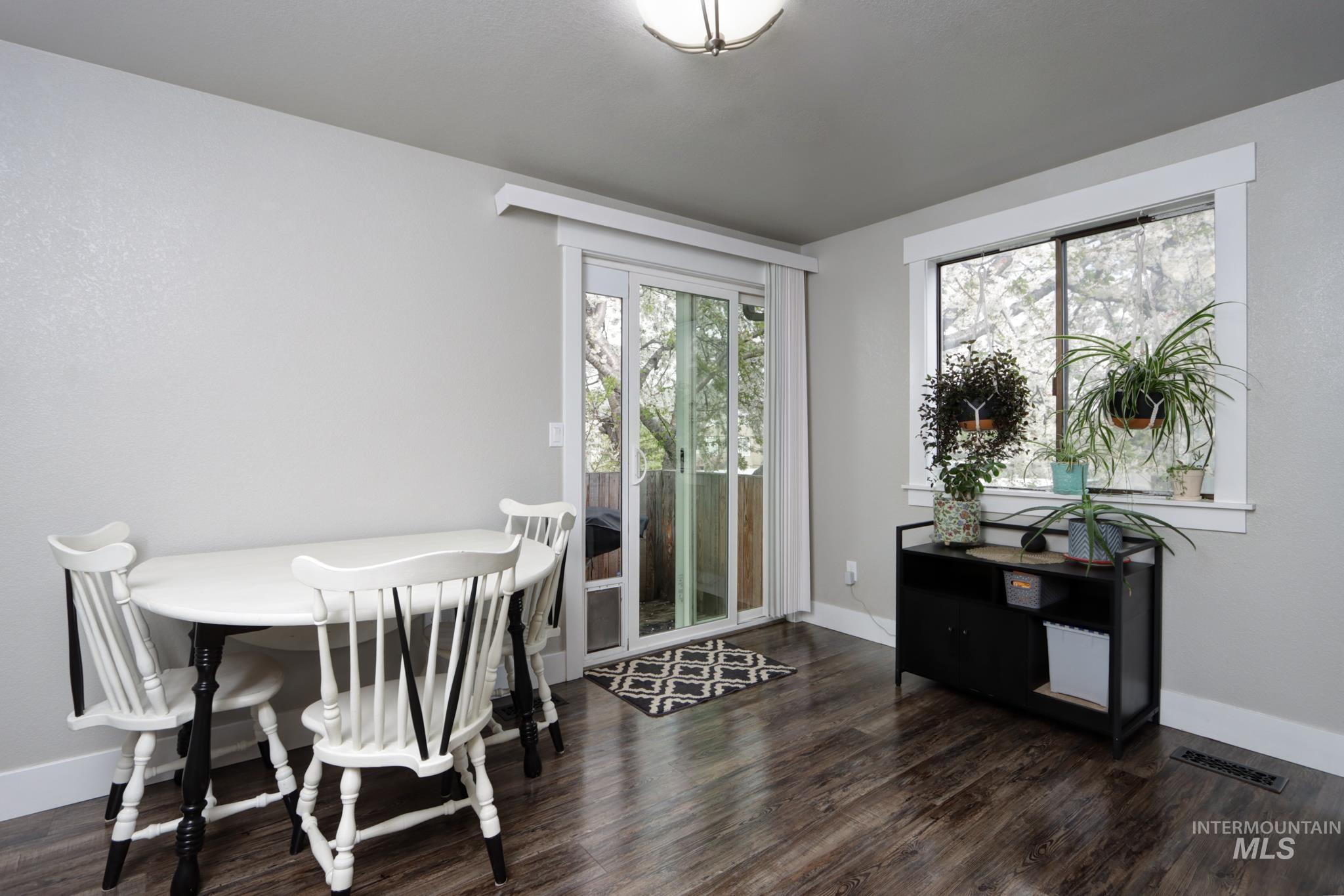 Dining area featuring dark wood-type flooring and baseboards