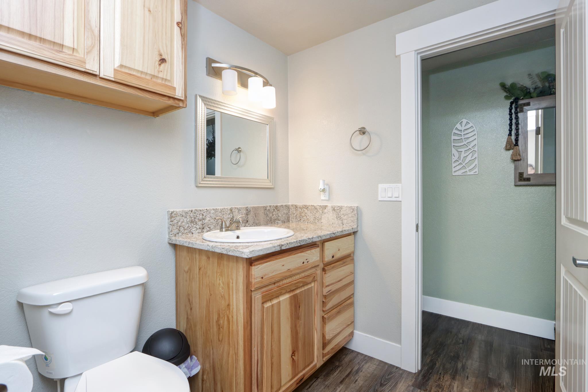 Half bath with vanity and dark wood finished floors