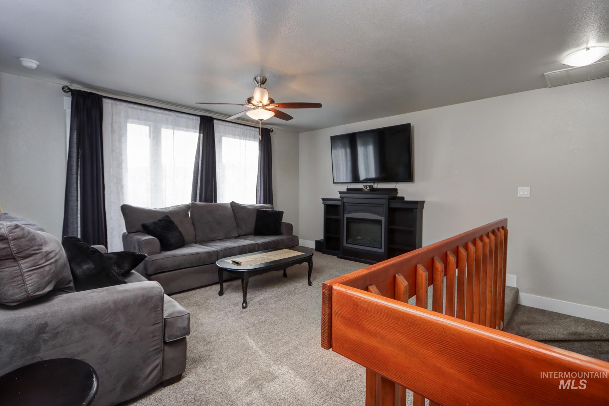 Living room with carpet floors and a ceiling fan