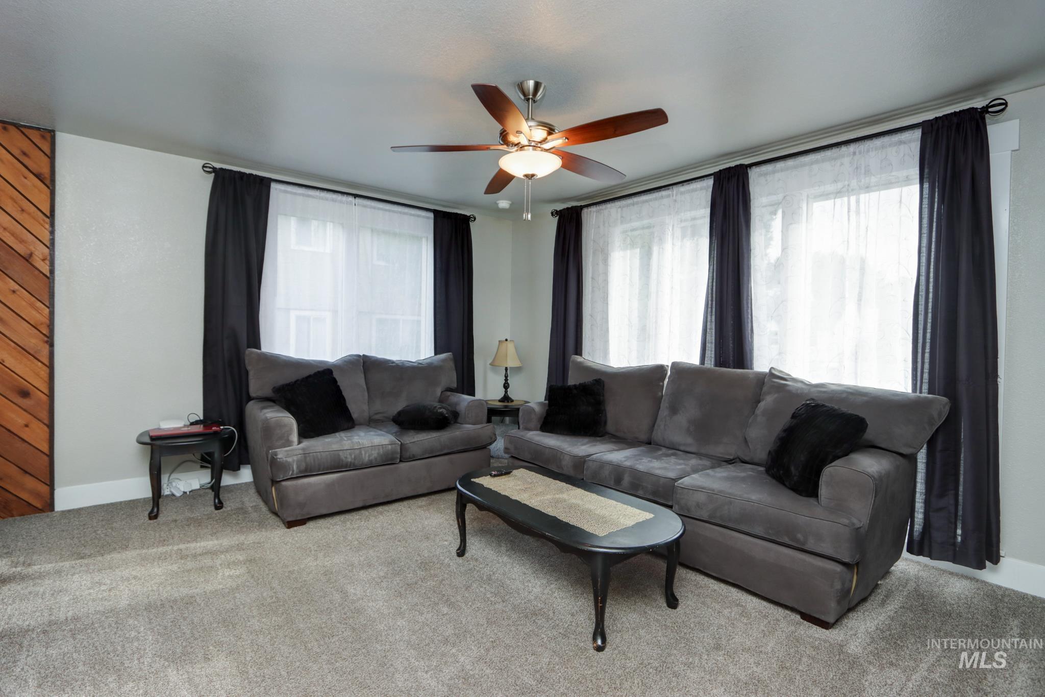 Living area with carpet flooring and ceiling fan