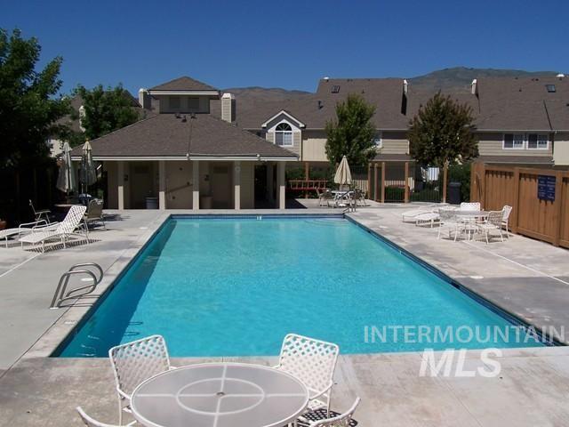 Community pool with a patio and outdoor dining space