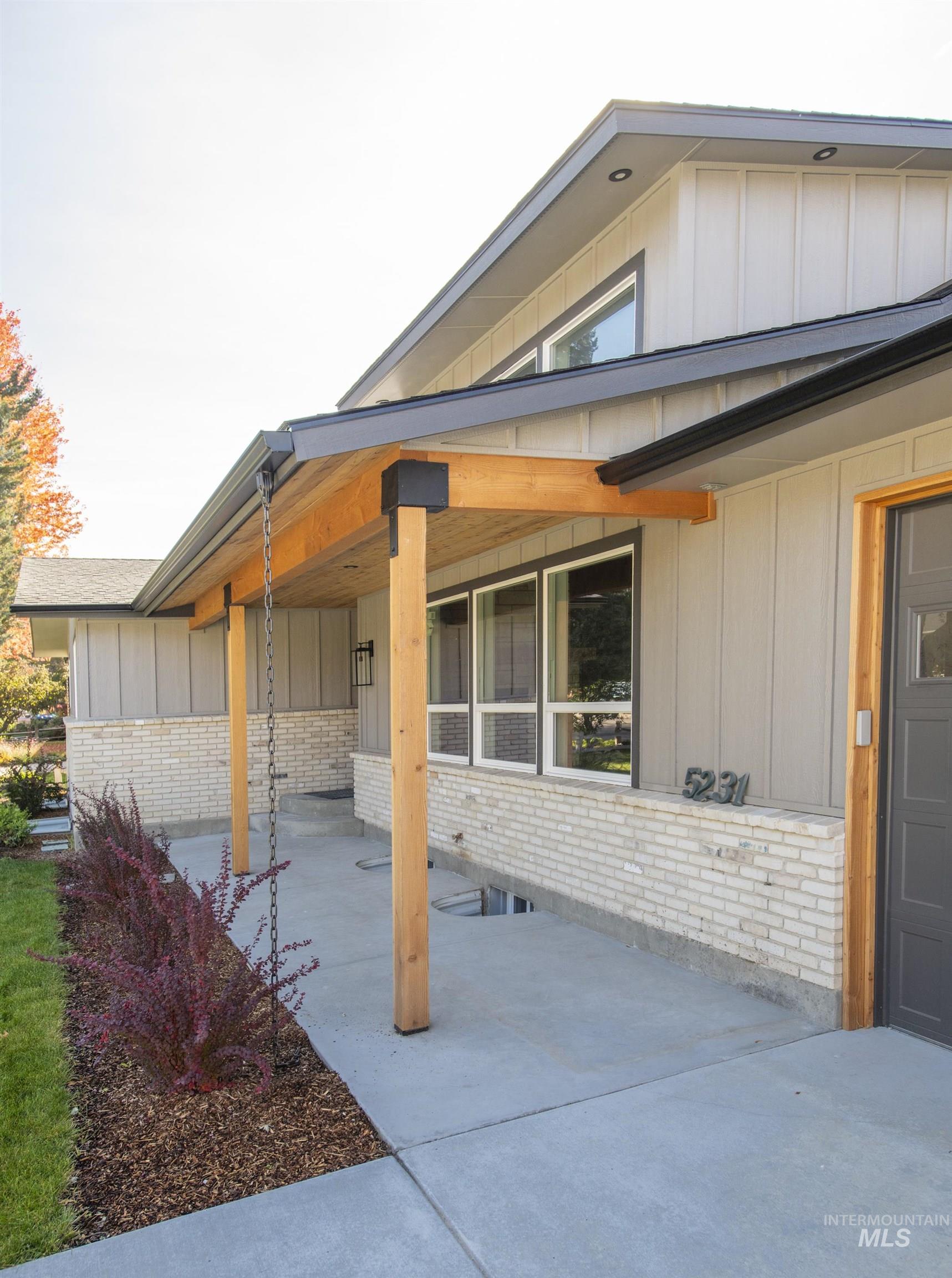 View of home's exterior featuring board and batten siding, a patio, and brick siding
