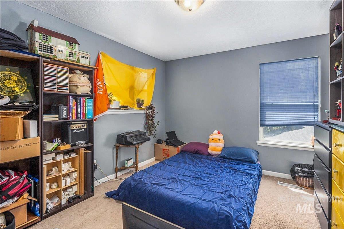 Bedroom featuring light colored carpet and a textured ceiling
