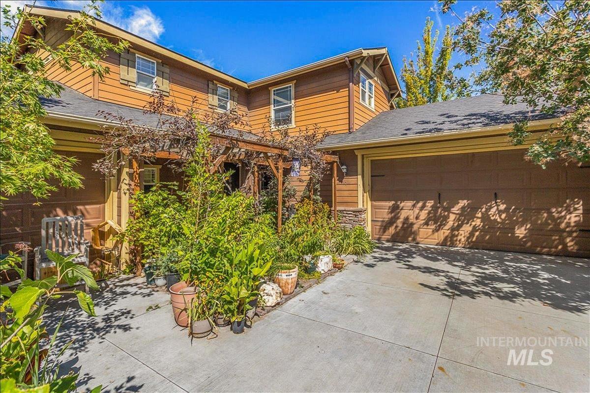 View of front of home with driveway, a garage, and roof with shingles