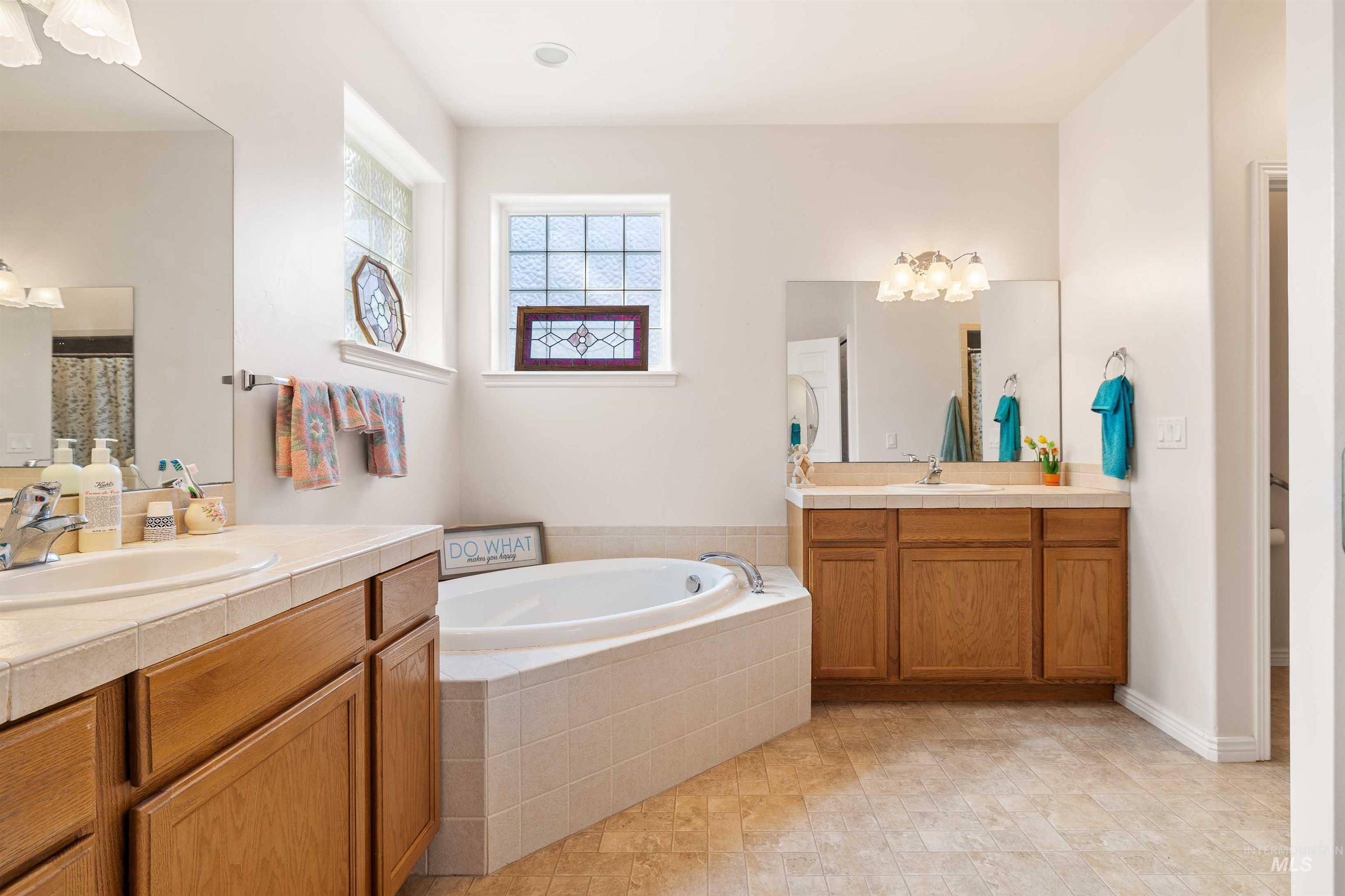 Bathroom with two vanities and a garden tub
