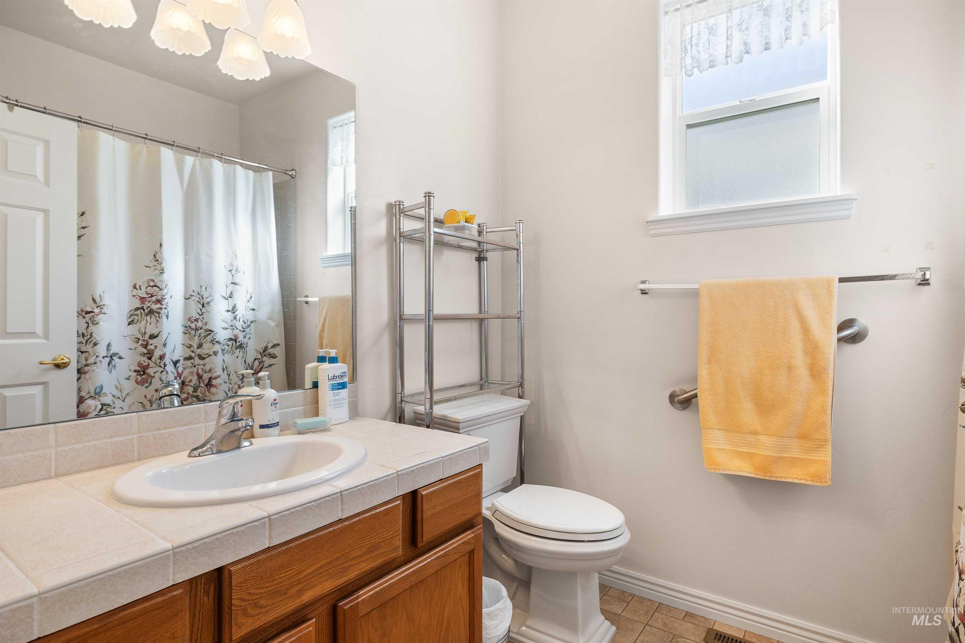 Full bathroom featuring vanity, a shower with shower curtain, and light tile patterned flooring