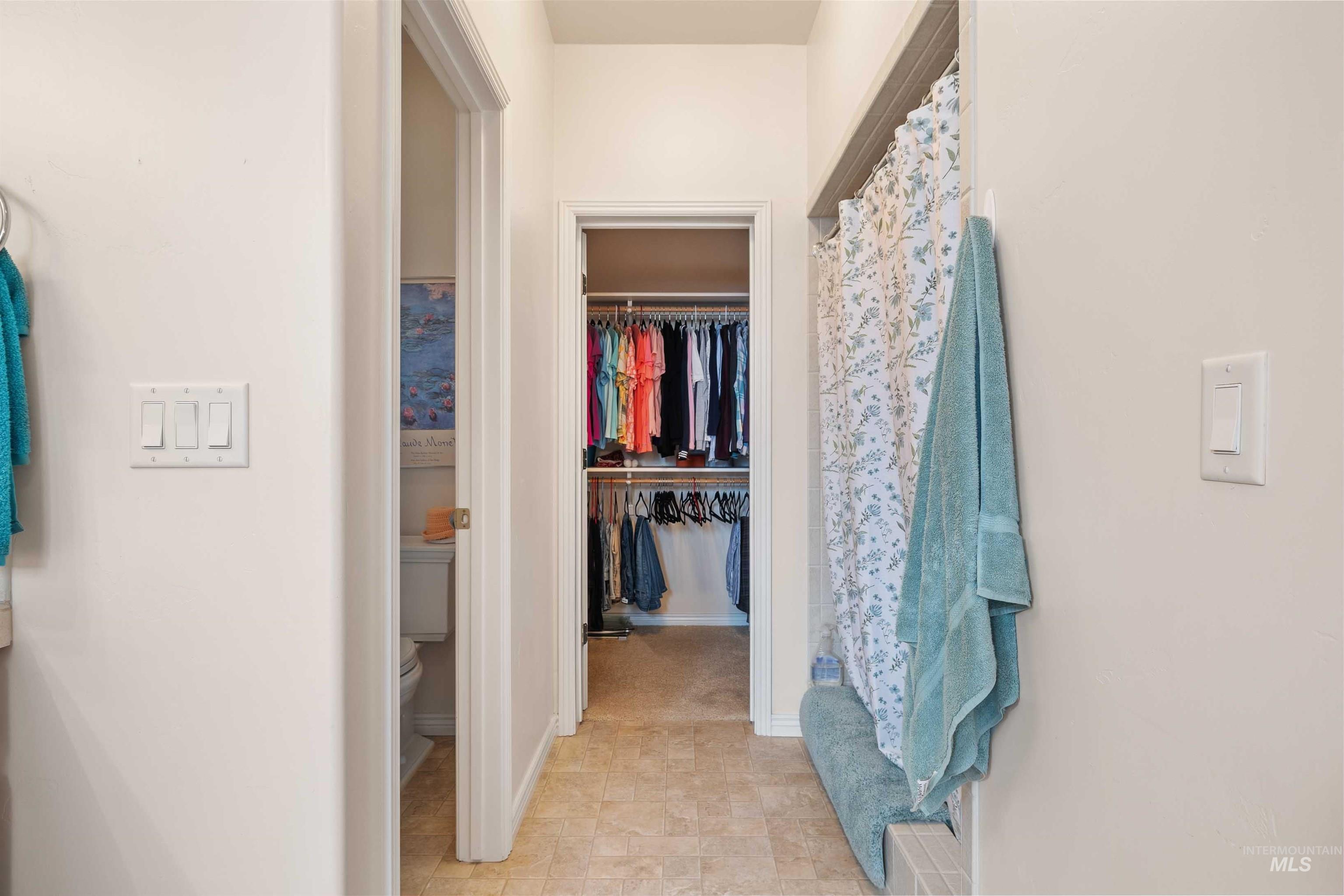Full bathroom featuring a spacious closet and a shower with curtain