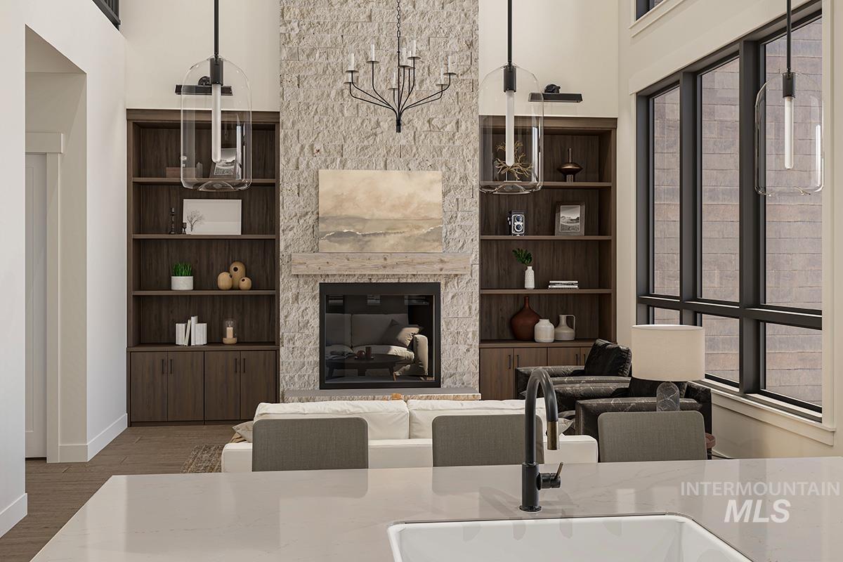 Living area with wood finished floors, a glass covered fireplace, and a high ceiling