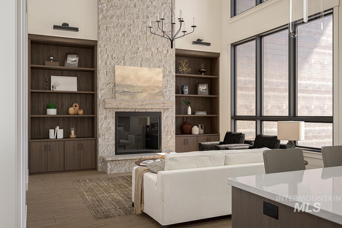 Living room with light wood-style floors, built in features, a fireplace, and a towering ceiling