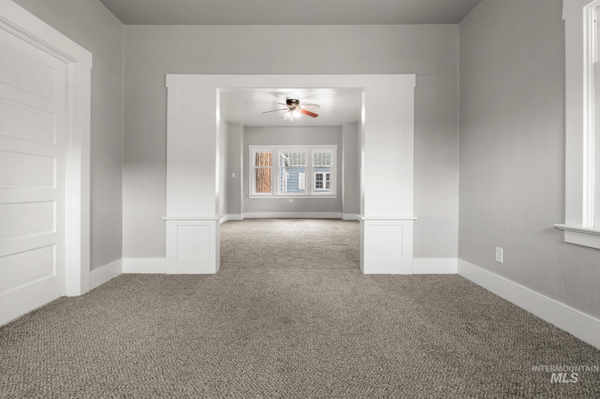 Empty room with carpet flooring and a ceiling fan