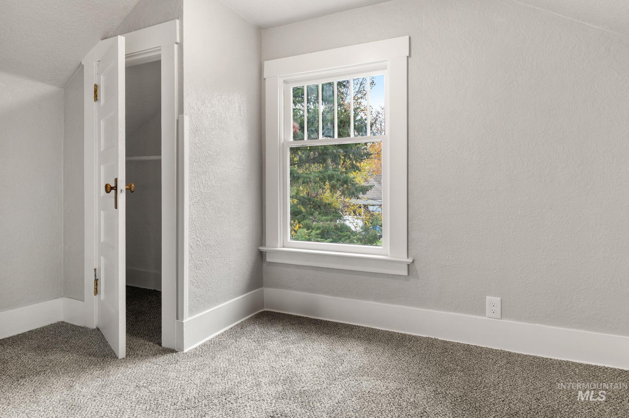 Bonus room featuring a textured wall and carpet flooring