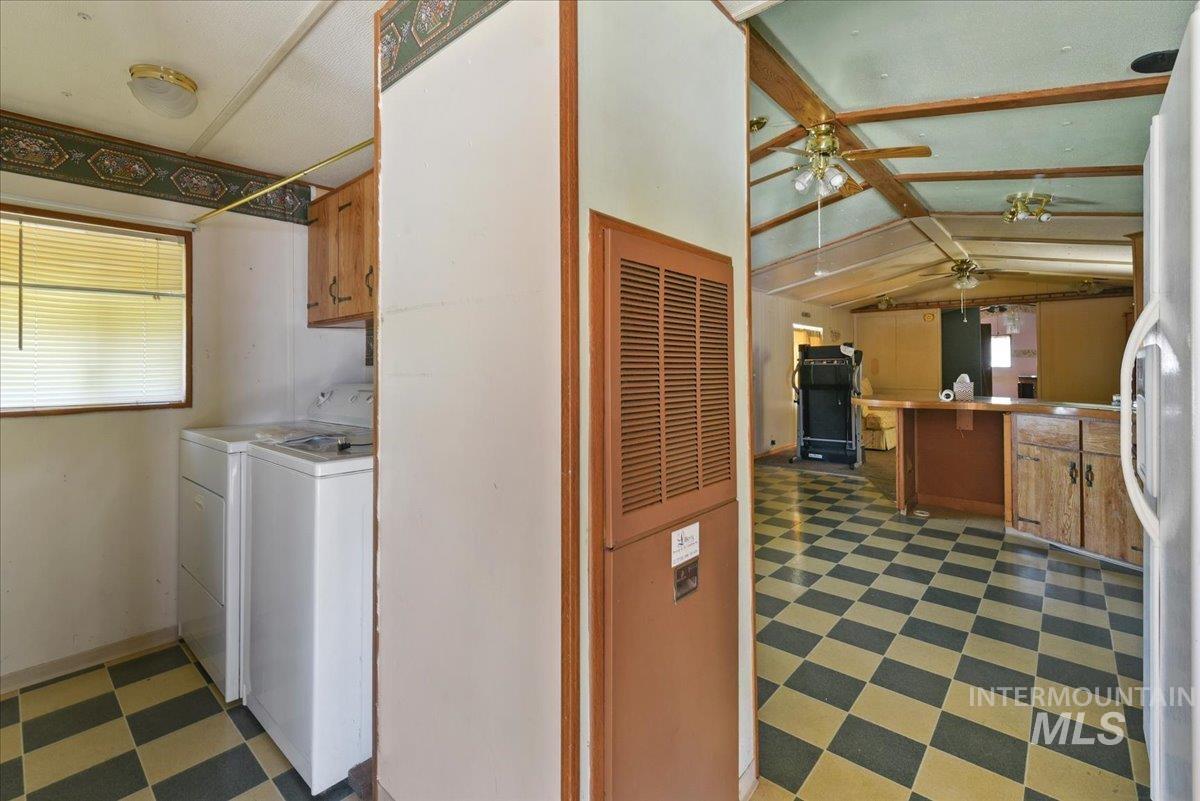Utility area with a window, upper cabinetry, and checkerboard flooring