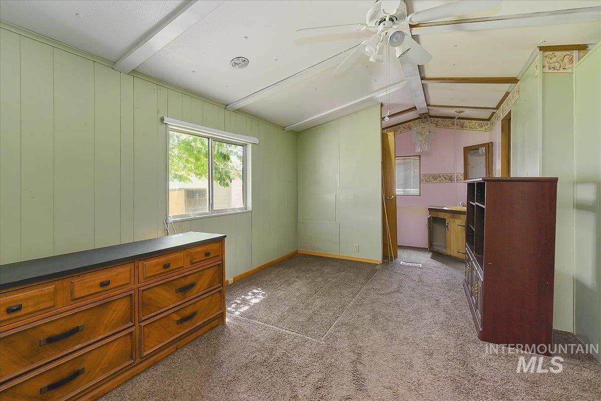 Room featuring a window with white blinds, light green paneled walls, and a ceiling fan with integrated lighting