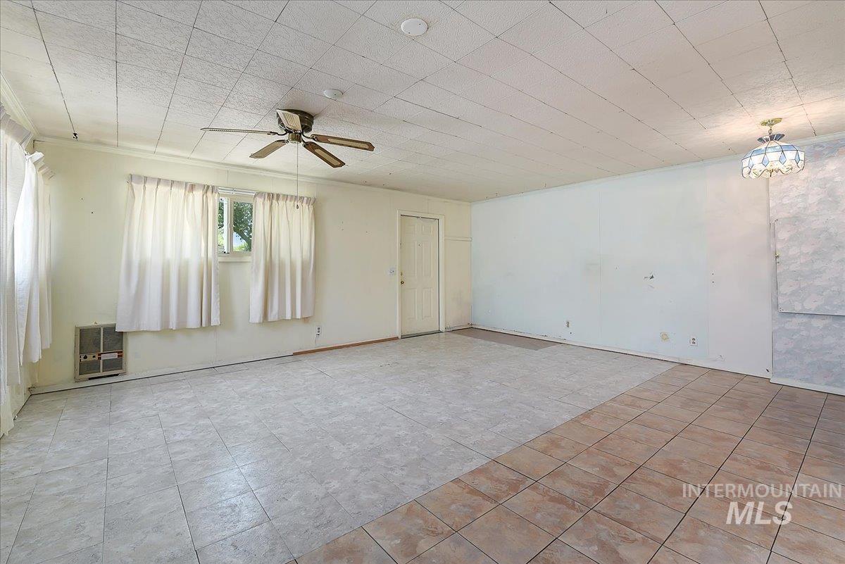 Spacious interior room featuring mixed tile flooring and multiple windows for natural light