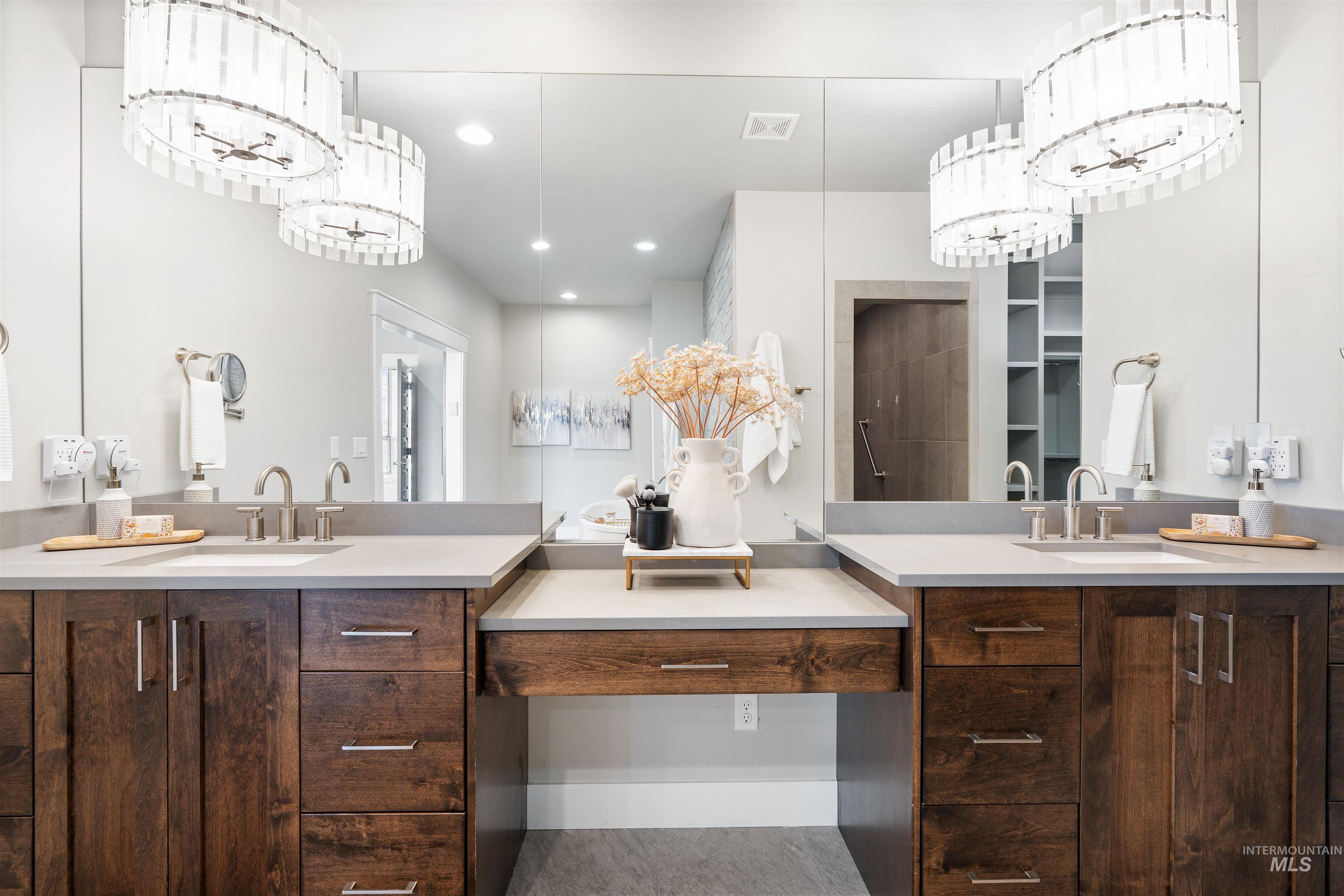 Bathroom featuring suspended lighting and vanity