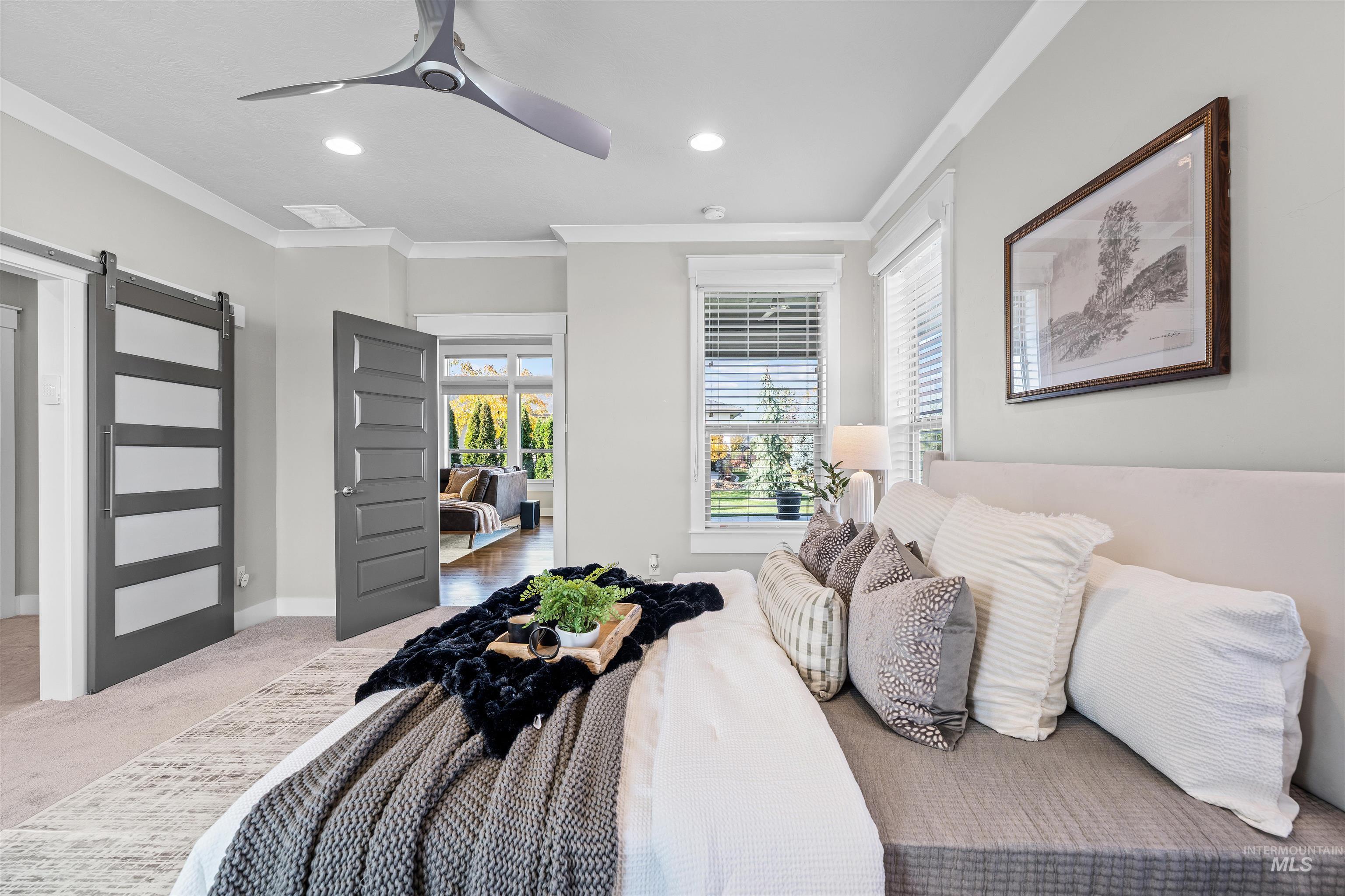 Bedroom featuring a barn door, carpet flooring, crown molding, a ceiling fan, and recessed lighting