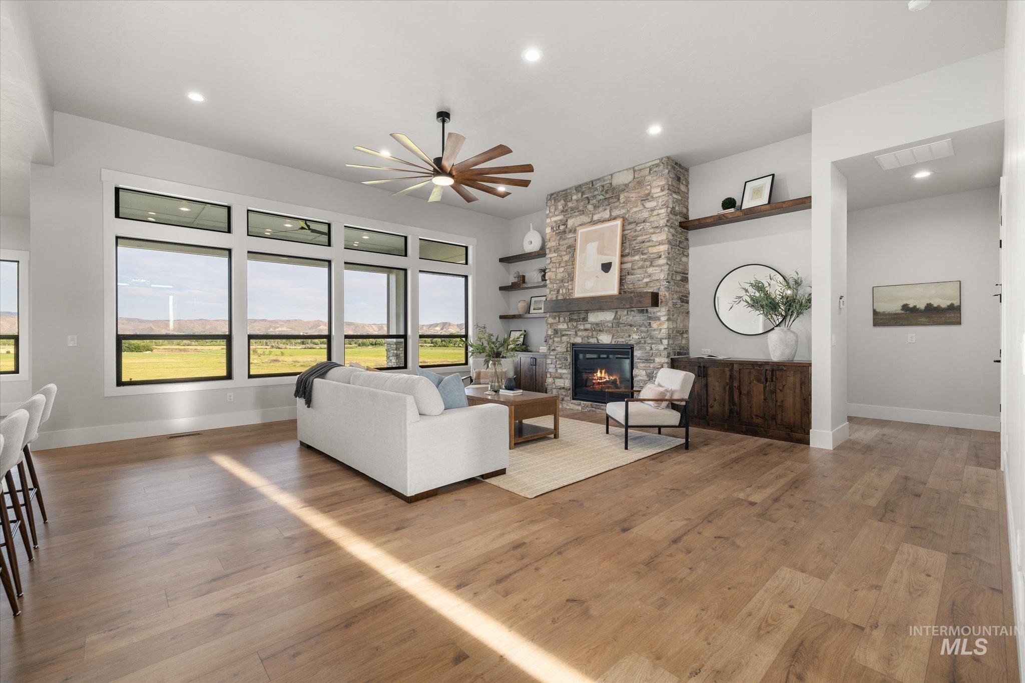 Living area featuring light wood-style floors, a fireplace, recessed lighting, and ceiling fan