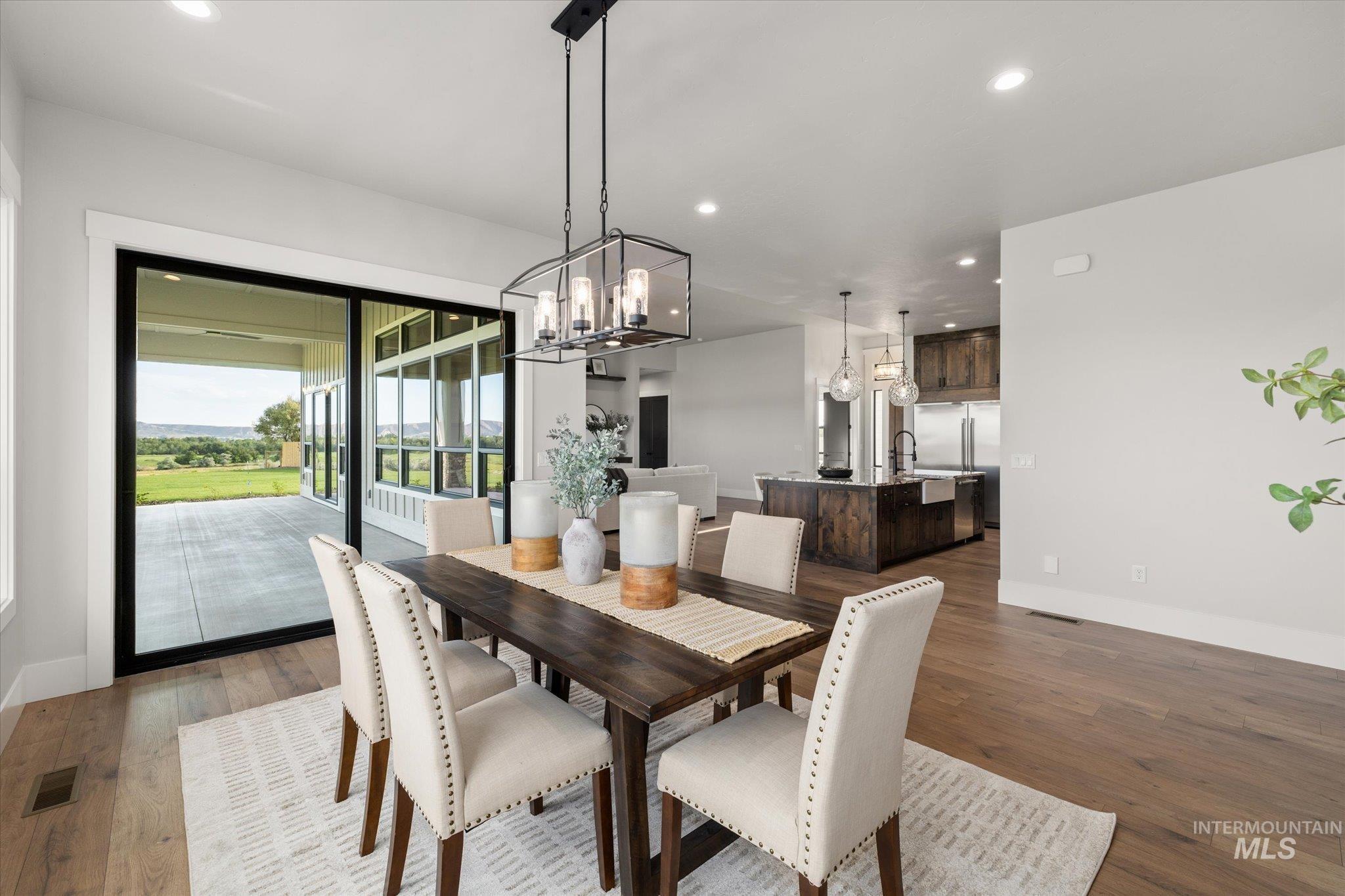 Dining area with recessed lighting, a chandelier, and dark wood-style flooring