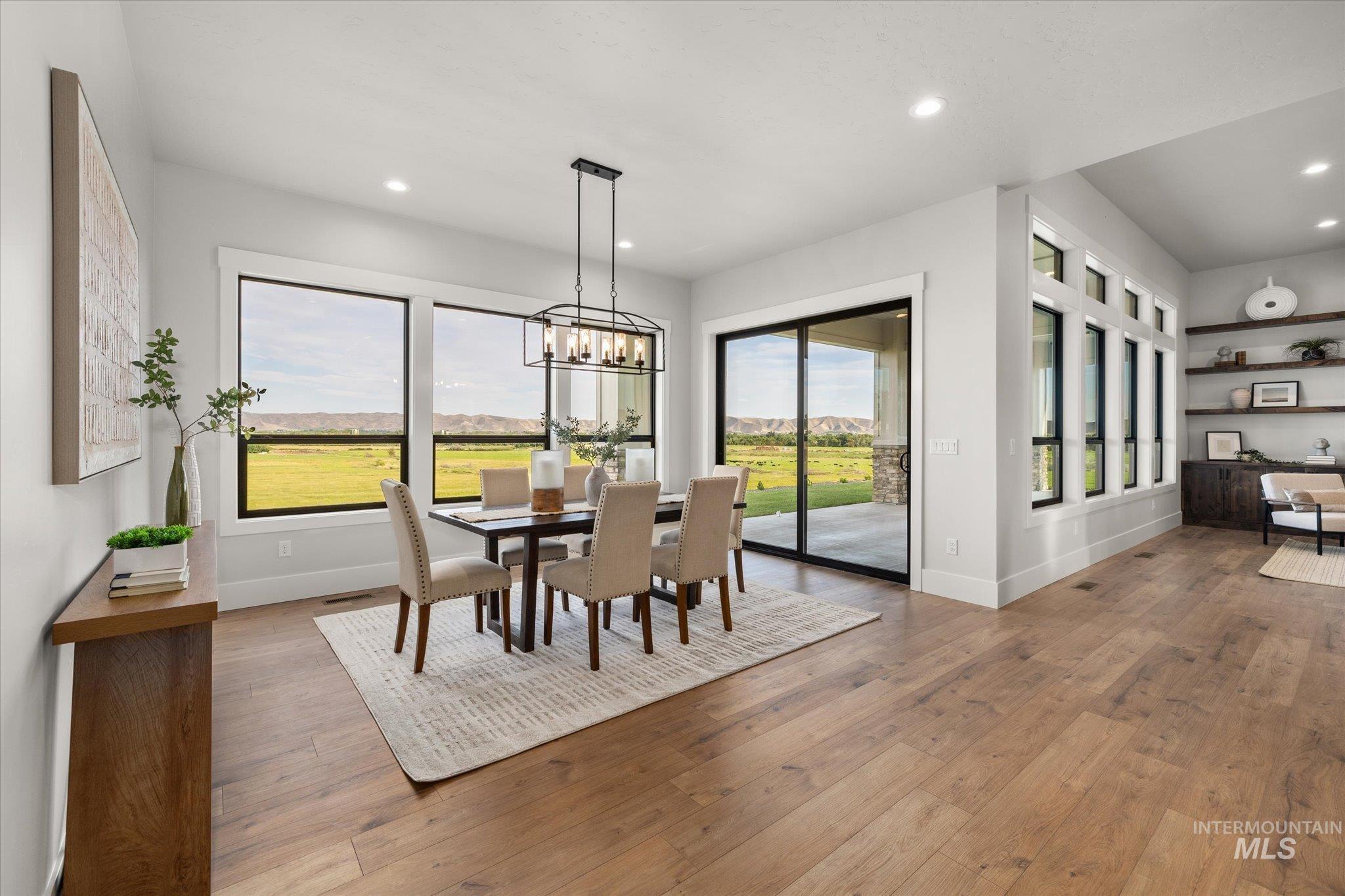 Dining area featuring healthy amount of natural light, hardwood / wood-style floors, a chandelier, and recessed lighting
