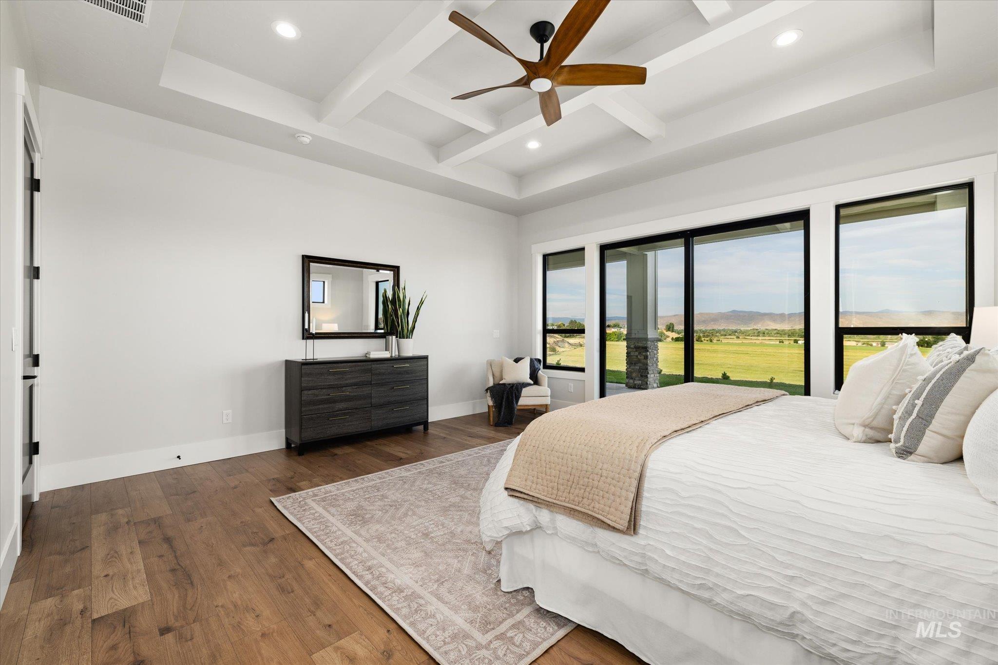 Bedroom featuring beamed ceiling, coffered ceiling, wood finished floors, recessed lighting, and access to outside