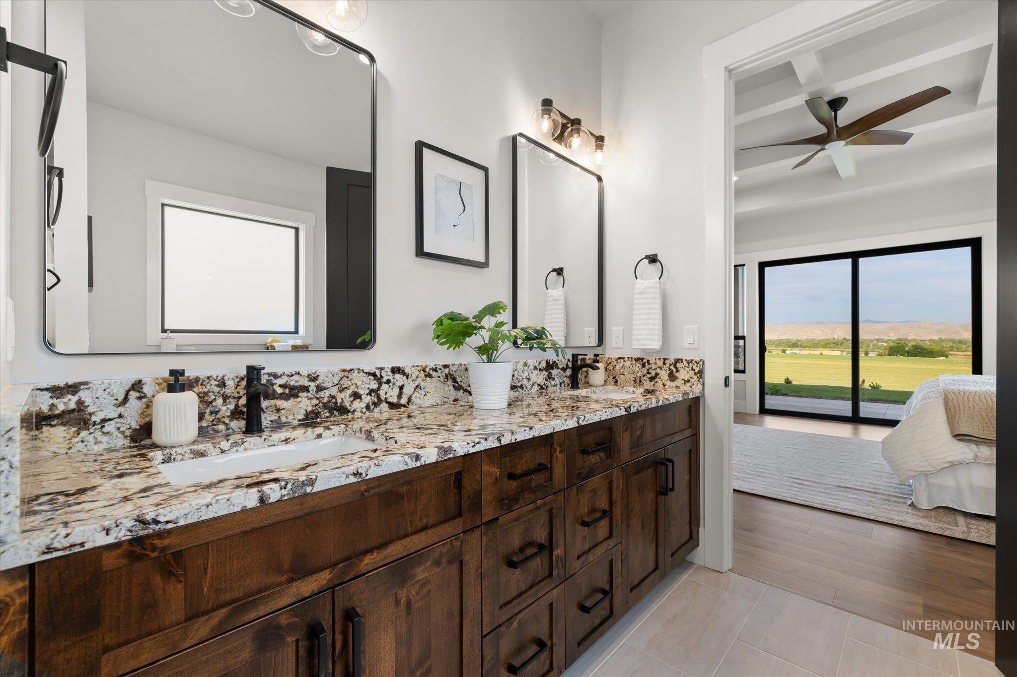 Full bathroom with double vanity, ensuite bath, beamed ceiling, light tile patterned floors, and ceiling fan