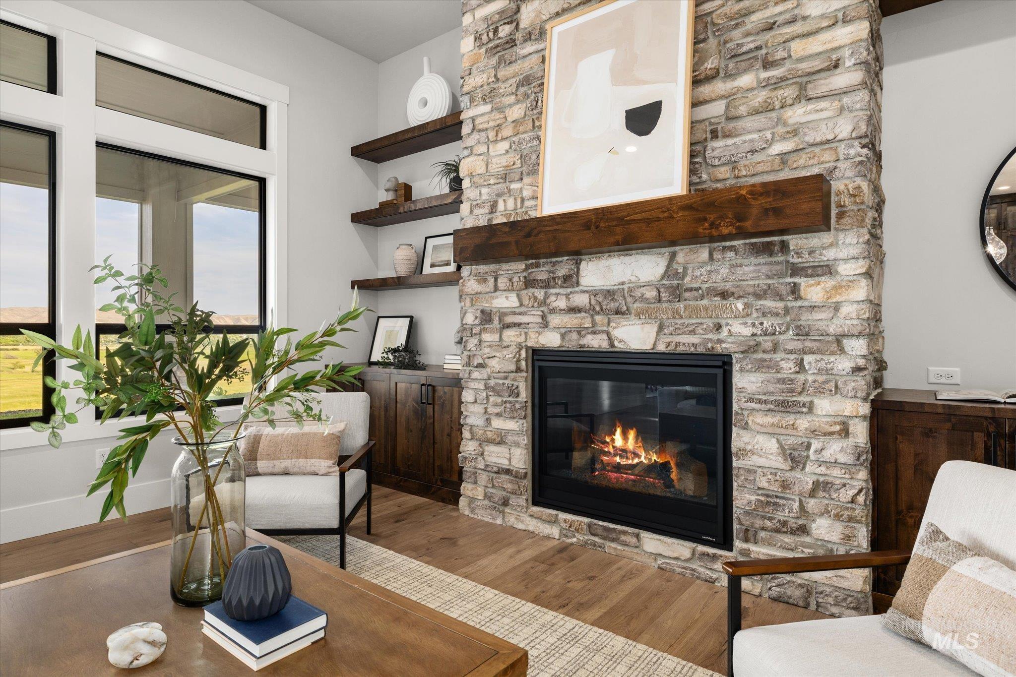 Living area featuring wood finished floors and a stone fireplace