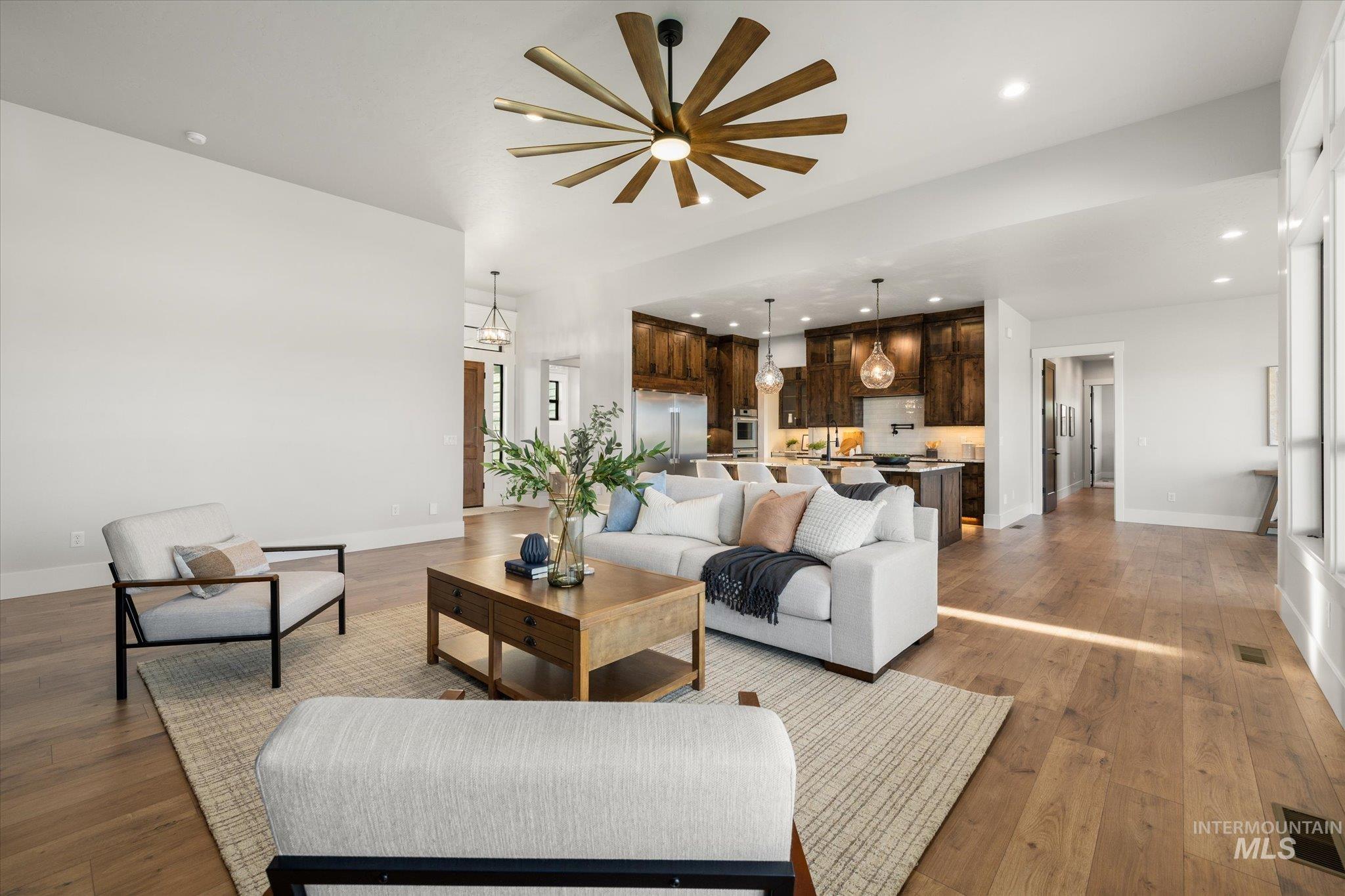 Living room with recessed lighting, wood finished floors, and a chandelier