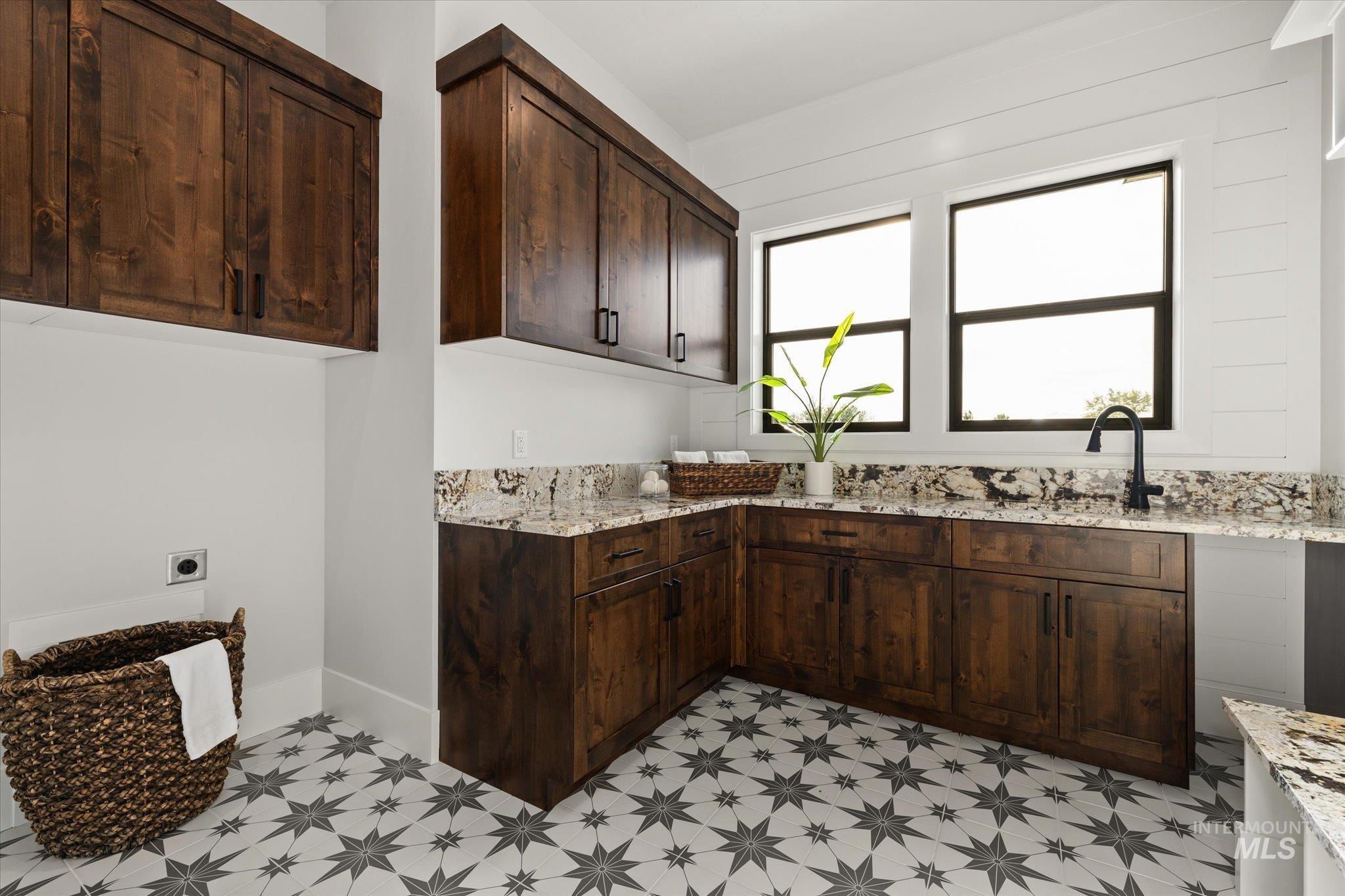 Laundry area with electric dryer hookup and cabinet space