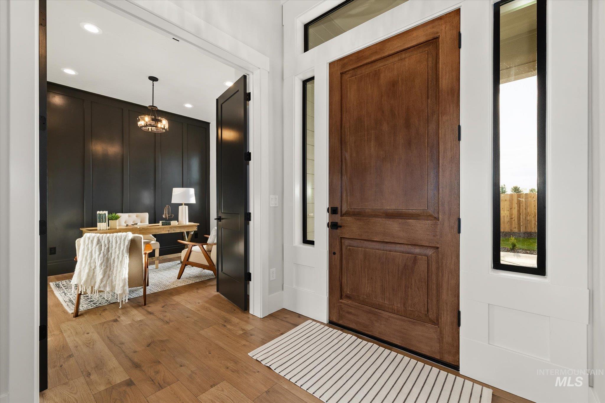 Entrance foyer featuring light wood-style flooring, a decorative wall, and recessed lighting
