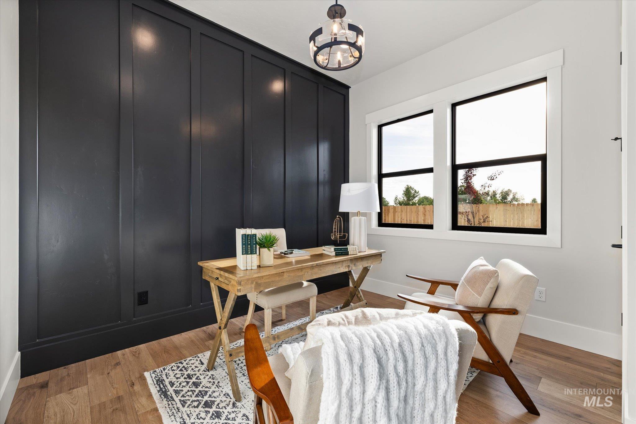 Office space with light wood-style floors and a chandelier