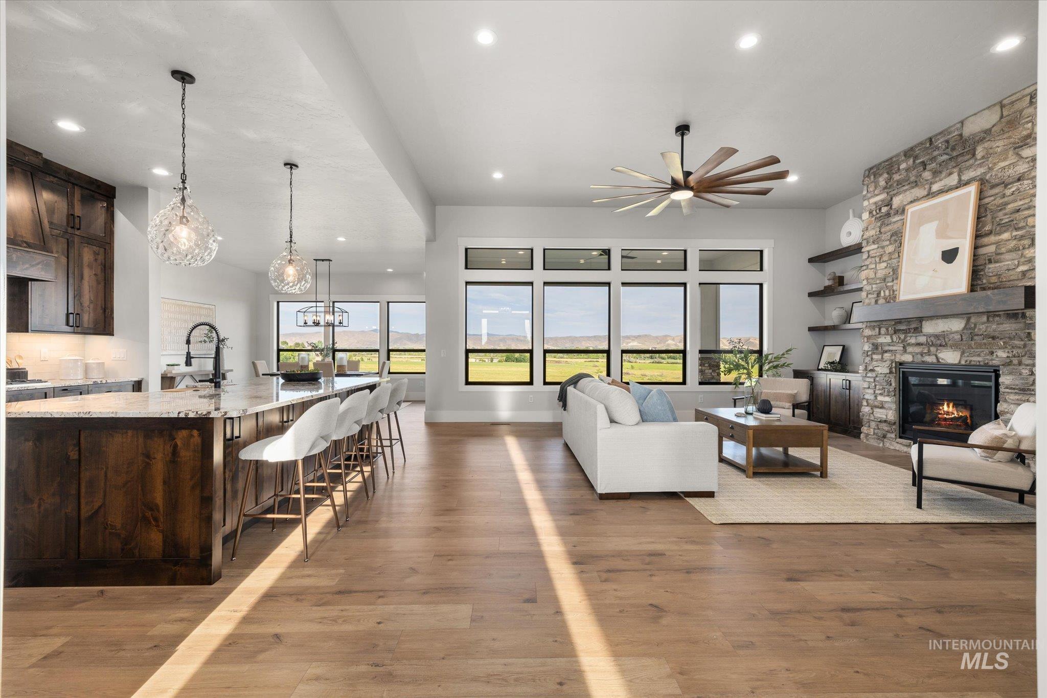 Living room with healthy amount of natural light, light wood-type flooring, recessed lighting, and a fireplace