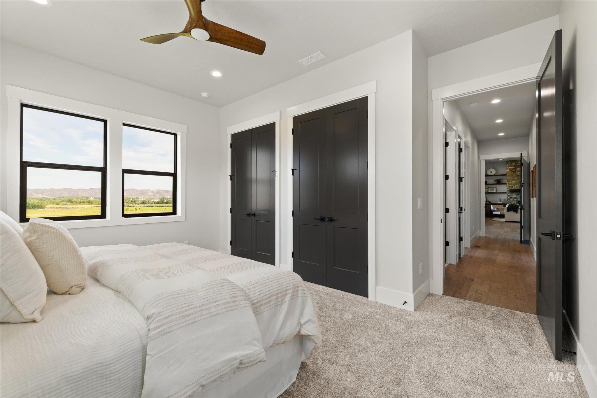 Bedroom with two closets, carpet floors, recessed lighting, and a ceiling fan