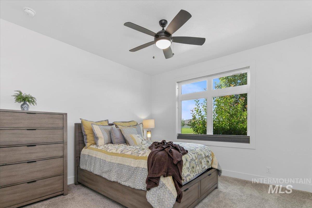 Bedroom featuring light colored carpet and a ceiling fan