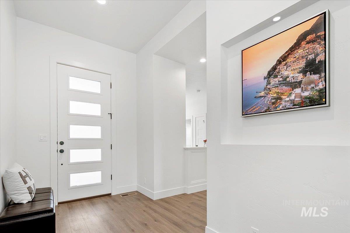 Foyer with light wood-style floors and recessed lighting
