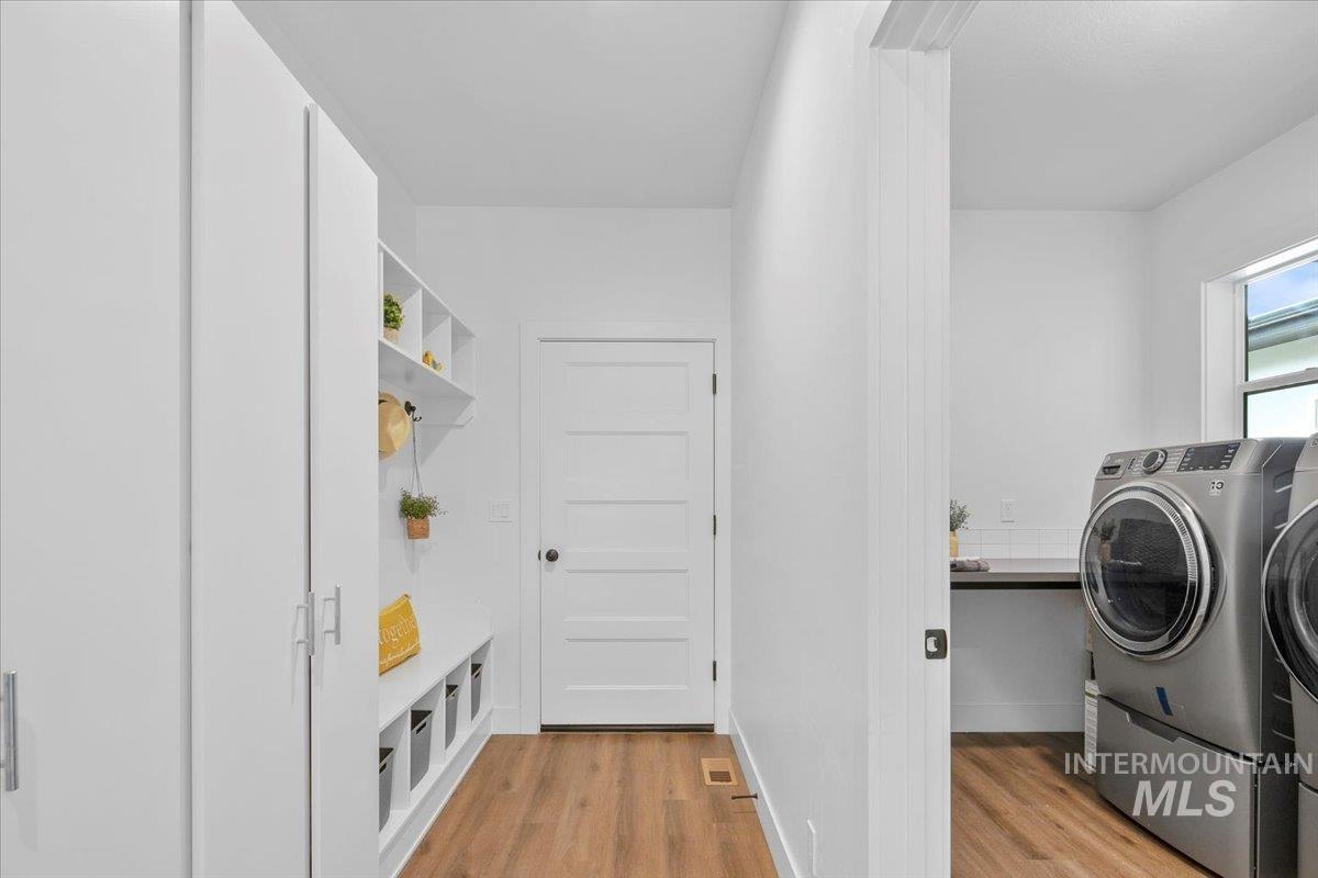 Washroom featuring light wood finished floors and washer and clothes dryer