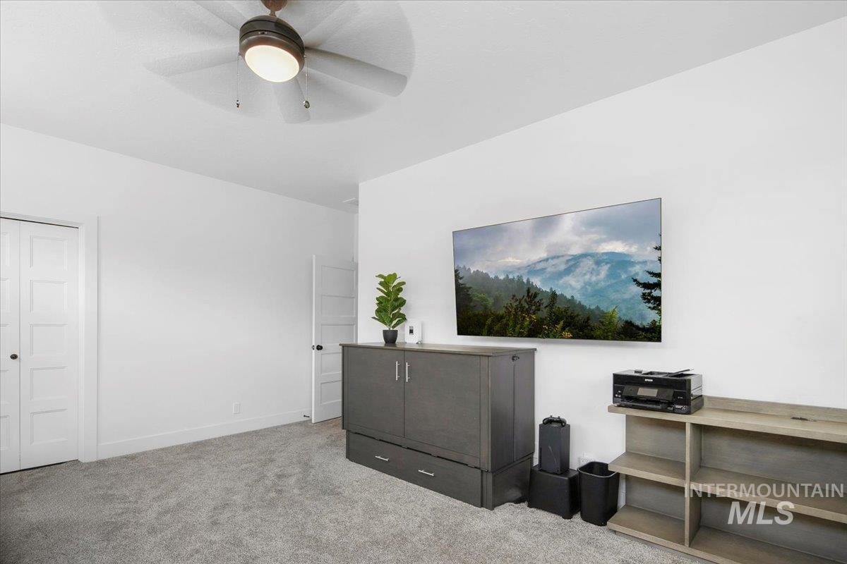 Interior space featuring light carpet and ceiling fan