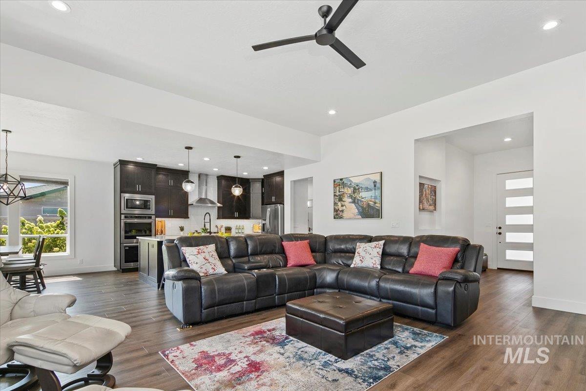 Living area featuring recessed lighting, dark wood-style flooring, and a ceiling fan