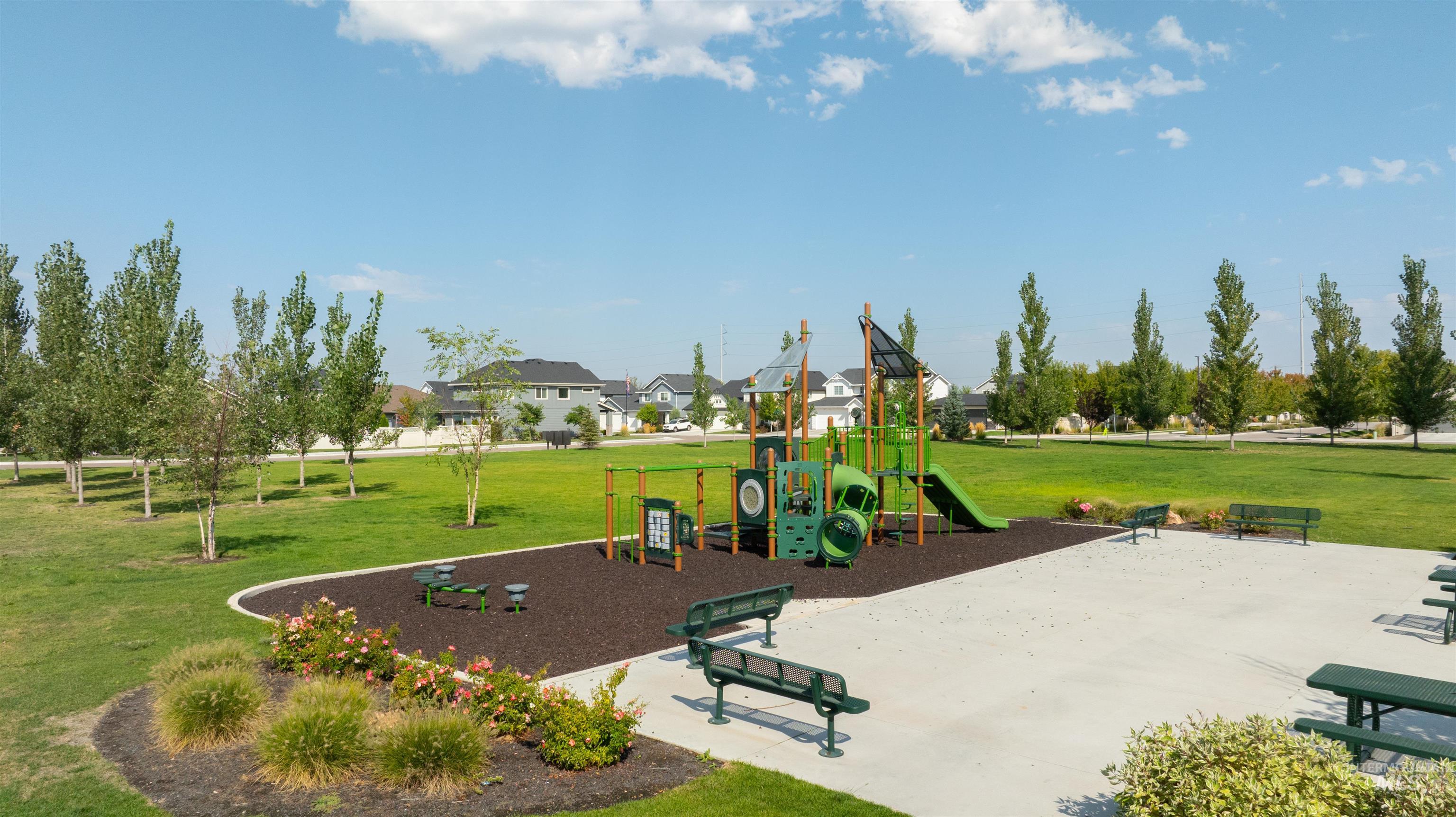 Communal playground featuring a lawn and a residential view