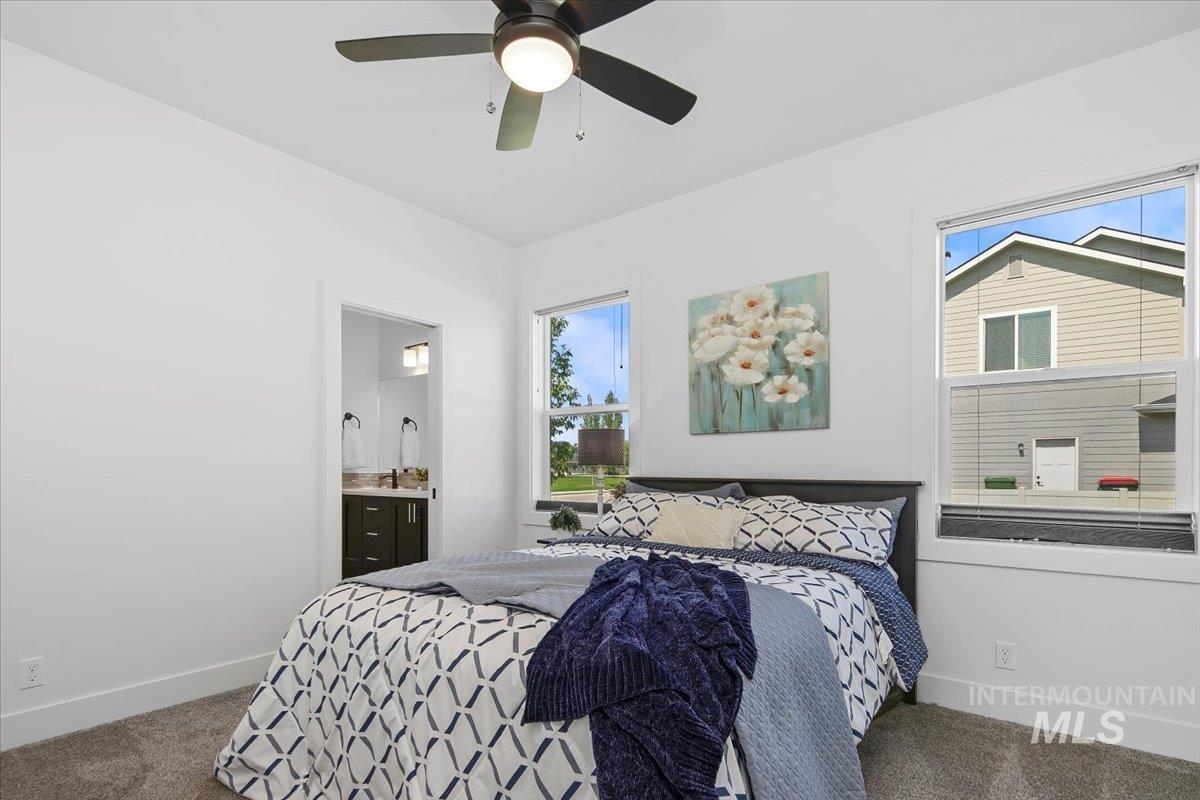 Bedroom with carpet flooring, connected bathroom, and a ceiling fan