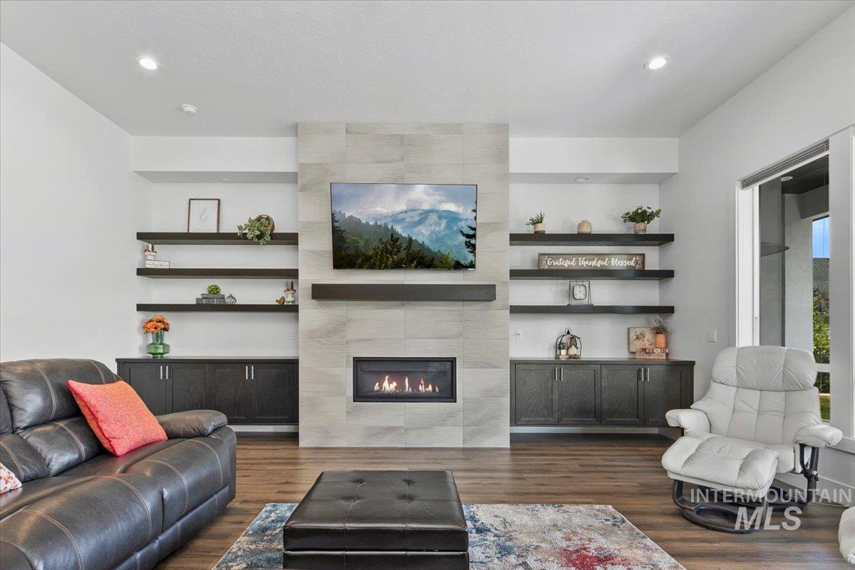 Living area featuring dark wood finished floors, a fireplace, and recessed lighting