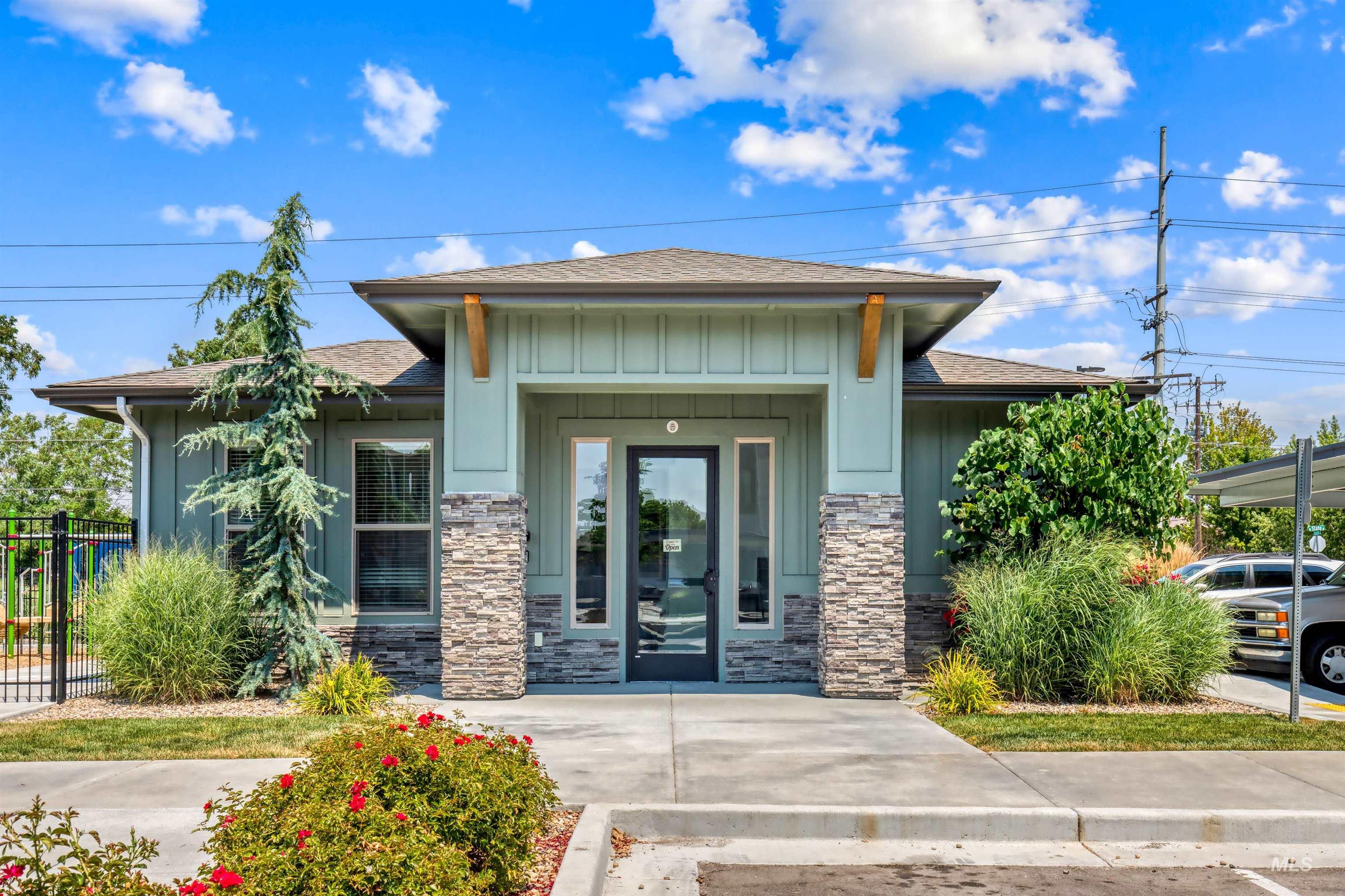Entrance to property featuring a shingled roof, board and batten siding, and stone siding