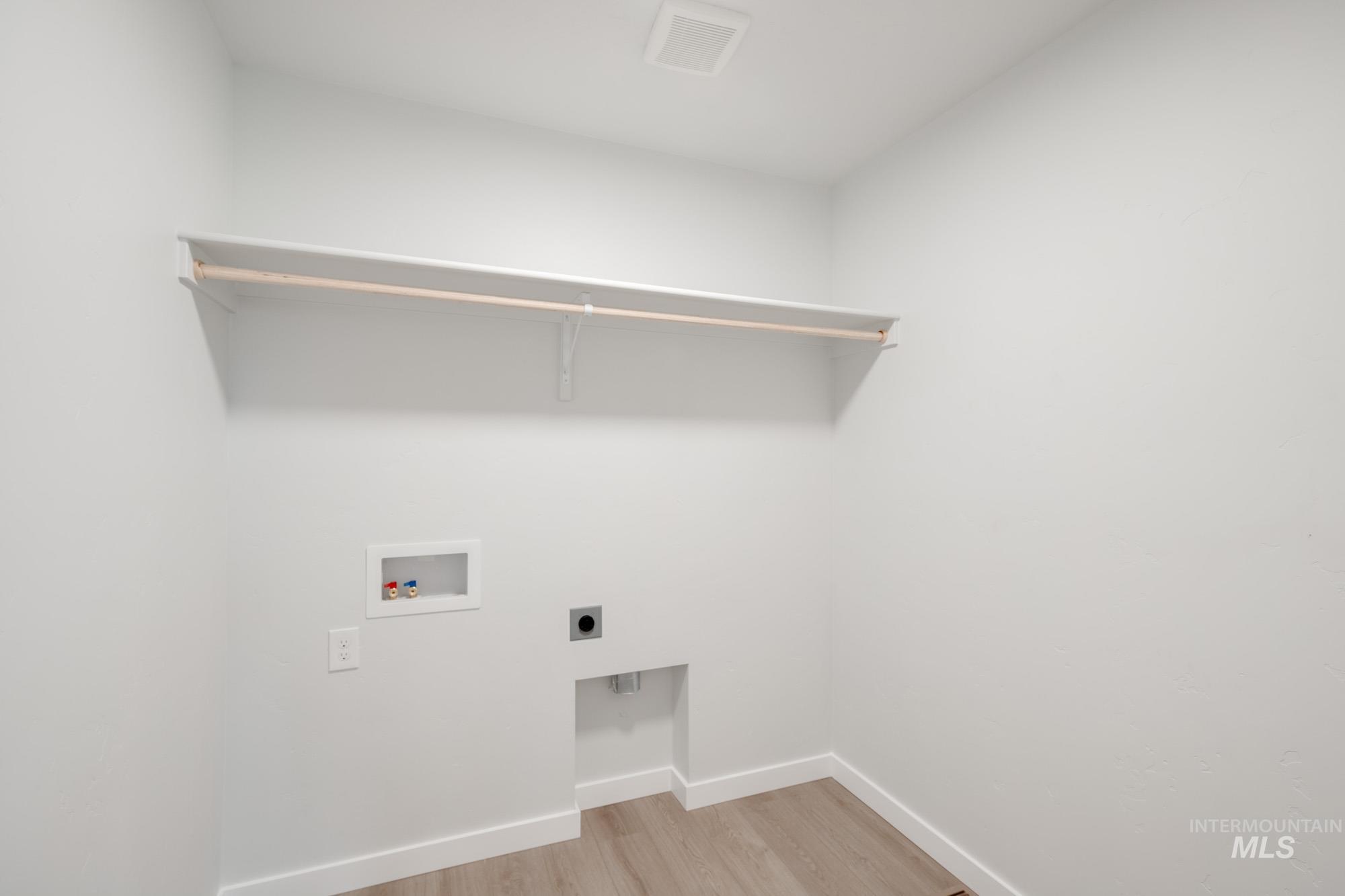 Laundry area featuring light wood-style floors, washer hookup, and hookup for an electric dryer