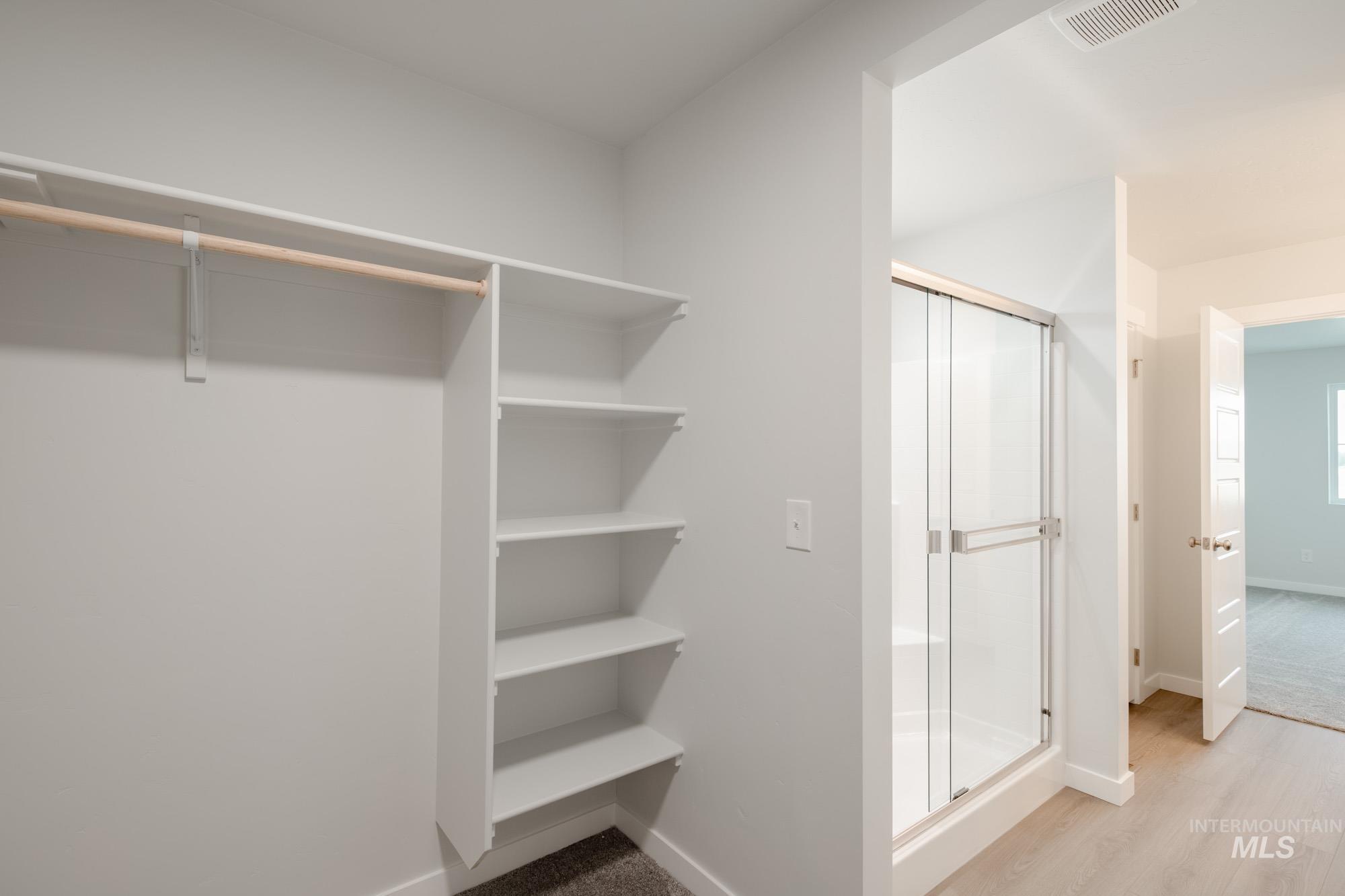 Spacious closet with light wood-style flooring