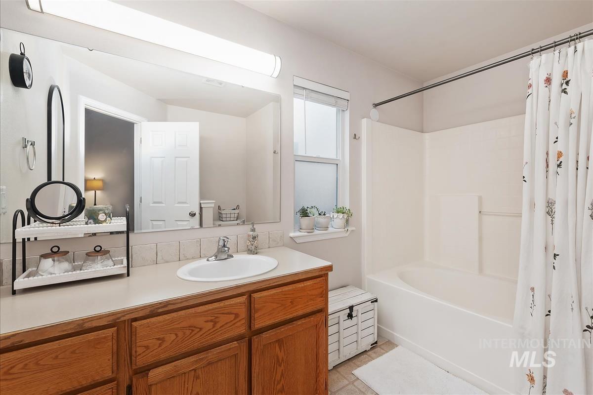 Bathroom with vanity and shower / bath combo with shower curtain