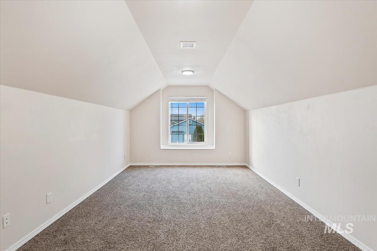 Bonus room with carpet flooring and baseboards