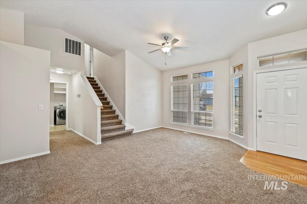 Entrance foyer featuring a ceiling fan, light colored carpet, and washer / clothes dryer