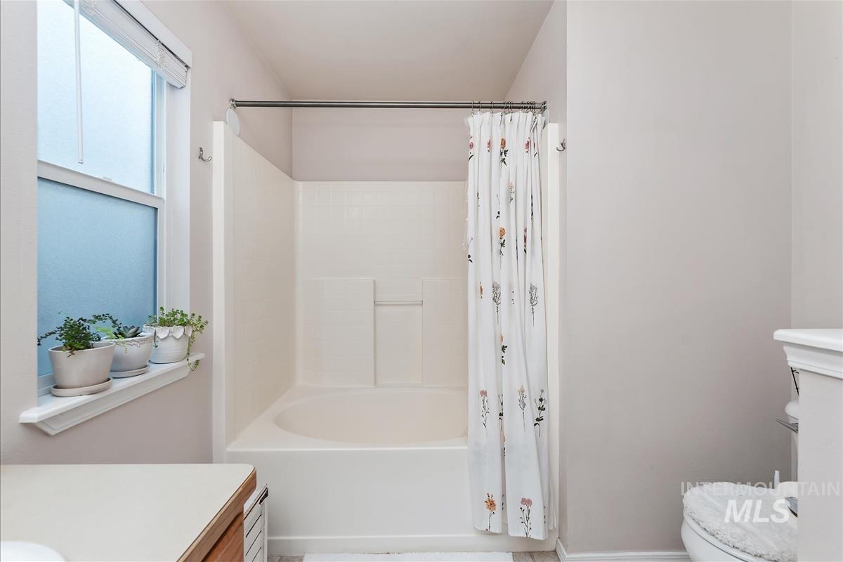 Bathroom with vanity and shower / tub combo with curtain