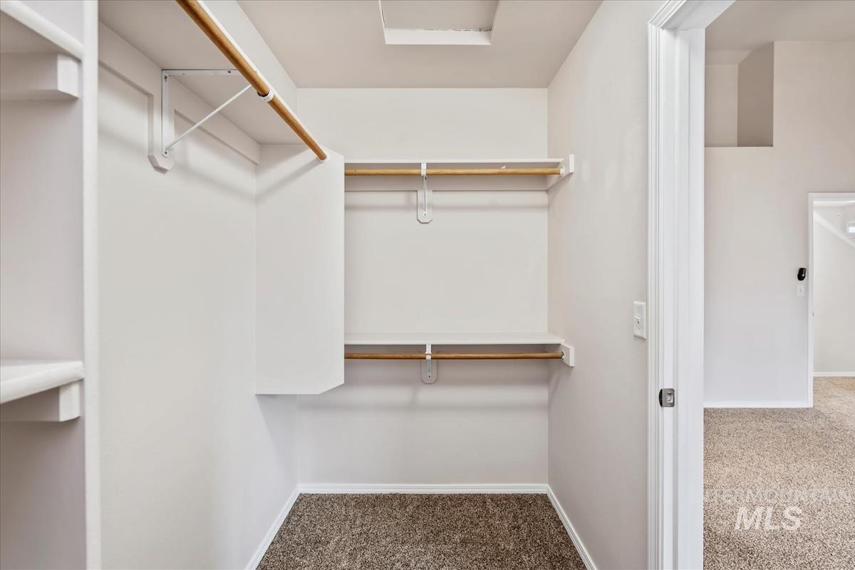 Walk in closet featuring dark colored carpet